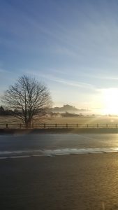 Image of sunrise through mist over empty road